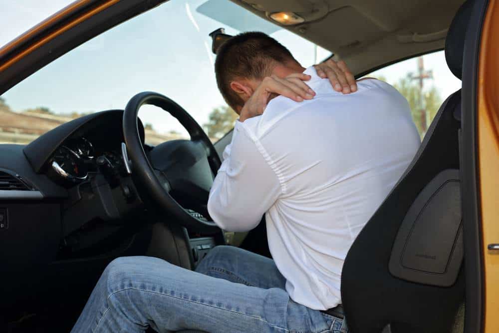 man holding his back after a car wreck